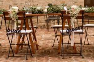 in questa foto il dettaglio delle scritte bride and groom sulle sedie degli sposi durante un matrimonio a Spao Borgo San Pietro