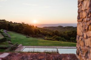 in questa foto al tramonto una parte della piscina circondata dal verde di Spao Borgo San Pietro