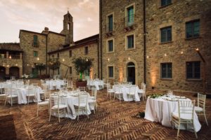 In questa foto la terrazza di Spao Borgo San Pietro allestita con tavoli rotondi e tetto di lucine in occasione di un ricevimento di nozze
