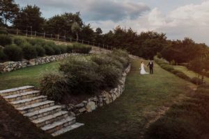 In questa foto una coppia di sposi fotografata mentre passeggia su uno degli splendidi prati verdi all'inglese di Spao Borgo San Pietro