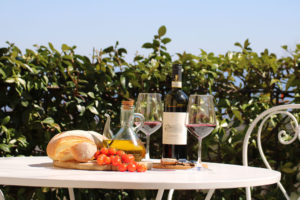 In questa foto pane, pomodoro, olio e calici di vino della zona su una tavola a Spao Borgo San Pietro