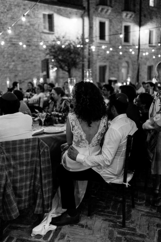 In questa foto gli sposi T e D di spalle, seduti al tavolo imperiale allestito a Spao Borgo San Pietro per il loro matrimonio da sogno in Umbria