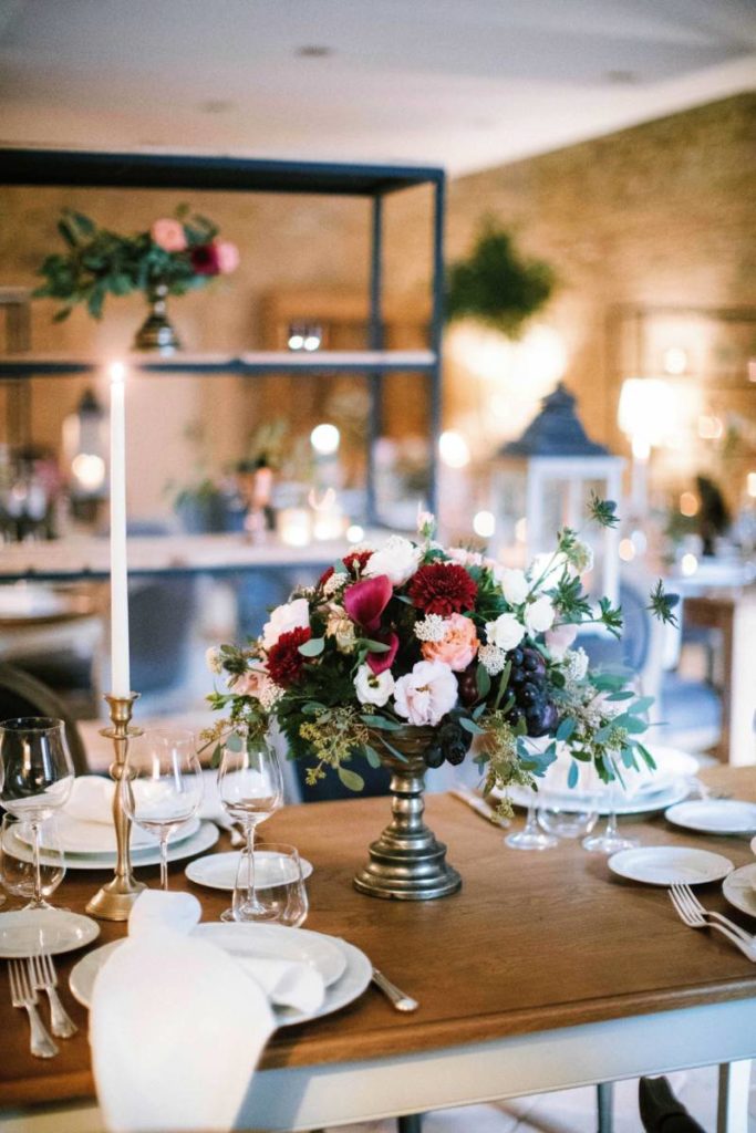 In questa foto un vaso di fiori fa da centratavola ad una mise en place in stile country chic