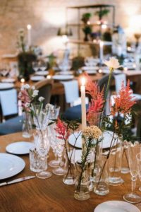 In questa foto fiori di campo, astilbe, calle e dalie nei vasetti della mise en place pensata dallo staff di Spao Borgo San Pietro per un matrimonio country chic