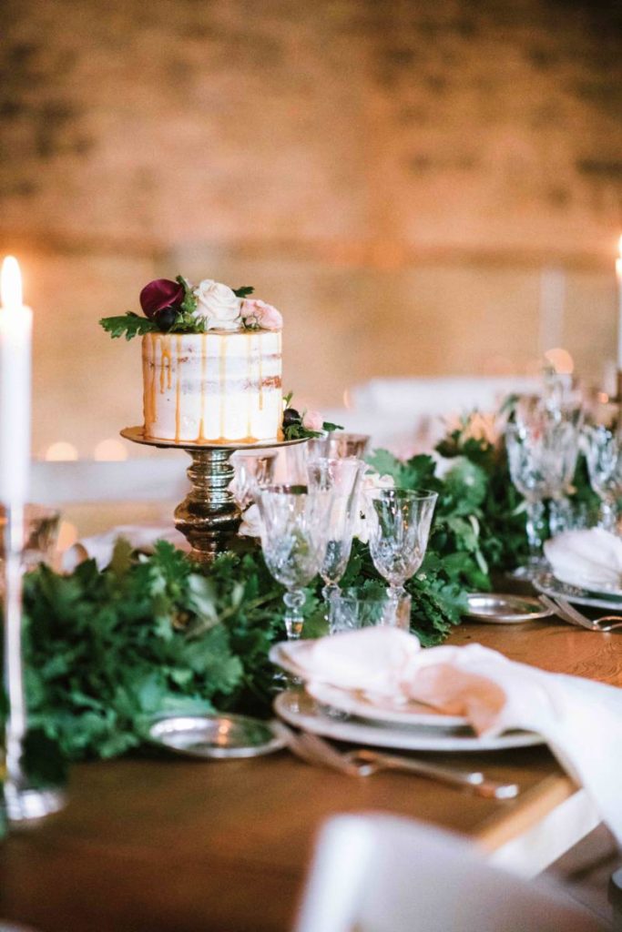In questa foto una mini wedding cake posta al centro del lungo tavolo imperiale allestito a spao borgo san pietro