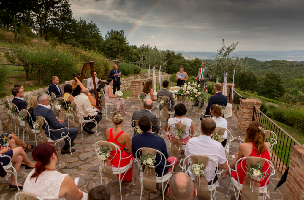 In questa foto gli ospiti di un matrimonio seduti su una delle terrazze nel giardino di spao borgo san pietro, mentre assistono alla cerimonia nuziale con rito civile