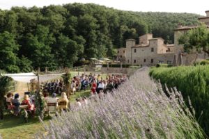 In questa foto gli invitati assistono all'unione con rito civile di una coppia di sposi, organizzata nel giardino esterno di spao borgo san pietro