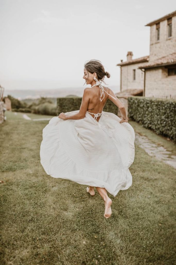 In questa foto una sposa in un momento di spensieratezza nella natura di Spao Borgo San Pietro, location matrimoni di lusso in Italia
