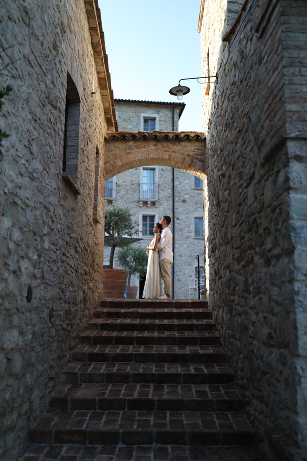 In questa foto una coppia di sposi in un momento di spensieratezza tra le vie di Spao Borgo San Pietro, location matrimoni di lusso in Italia